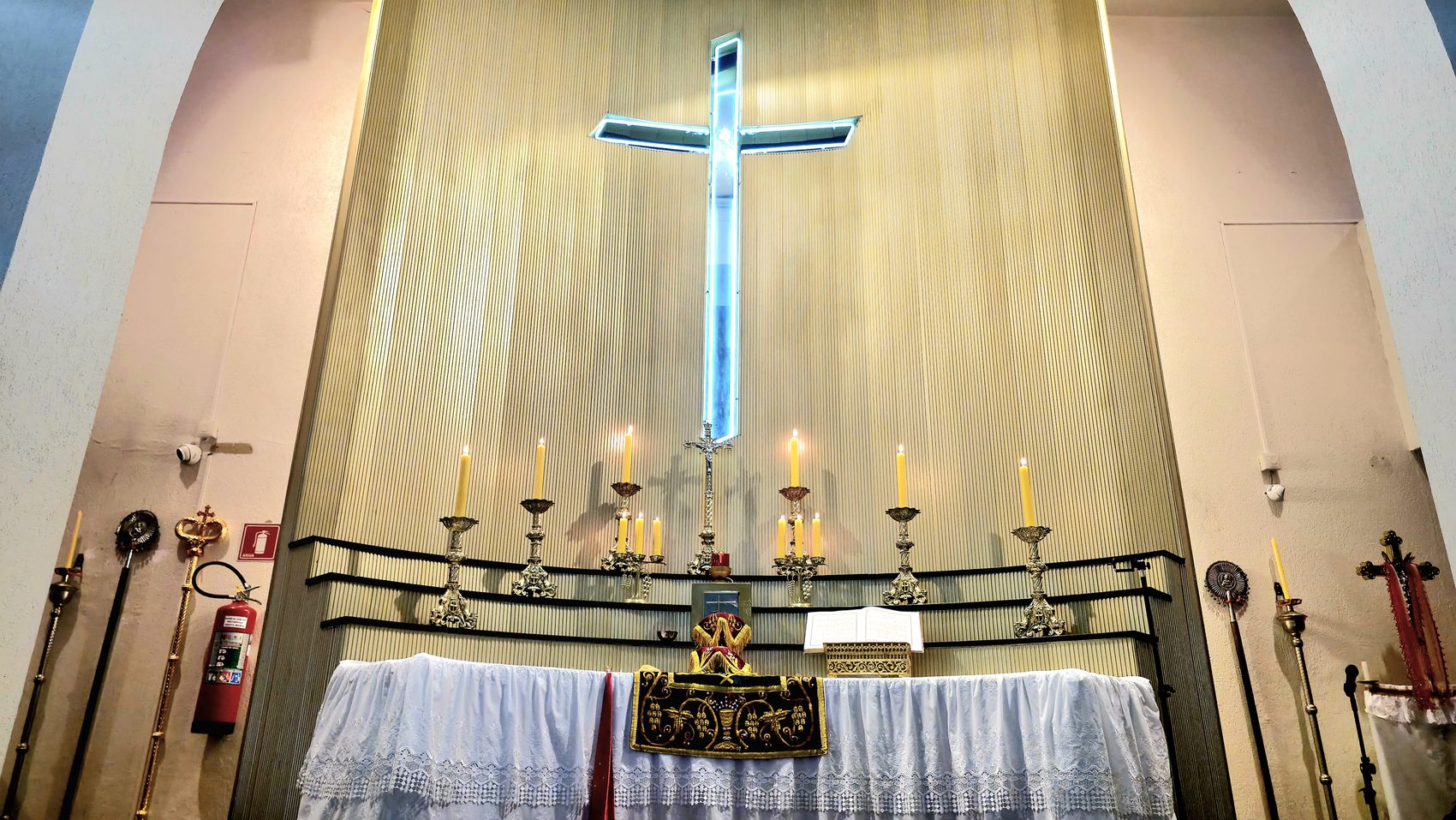 Interior da igreja com o altar e a cruz iluminada